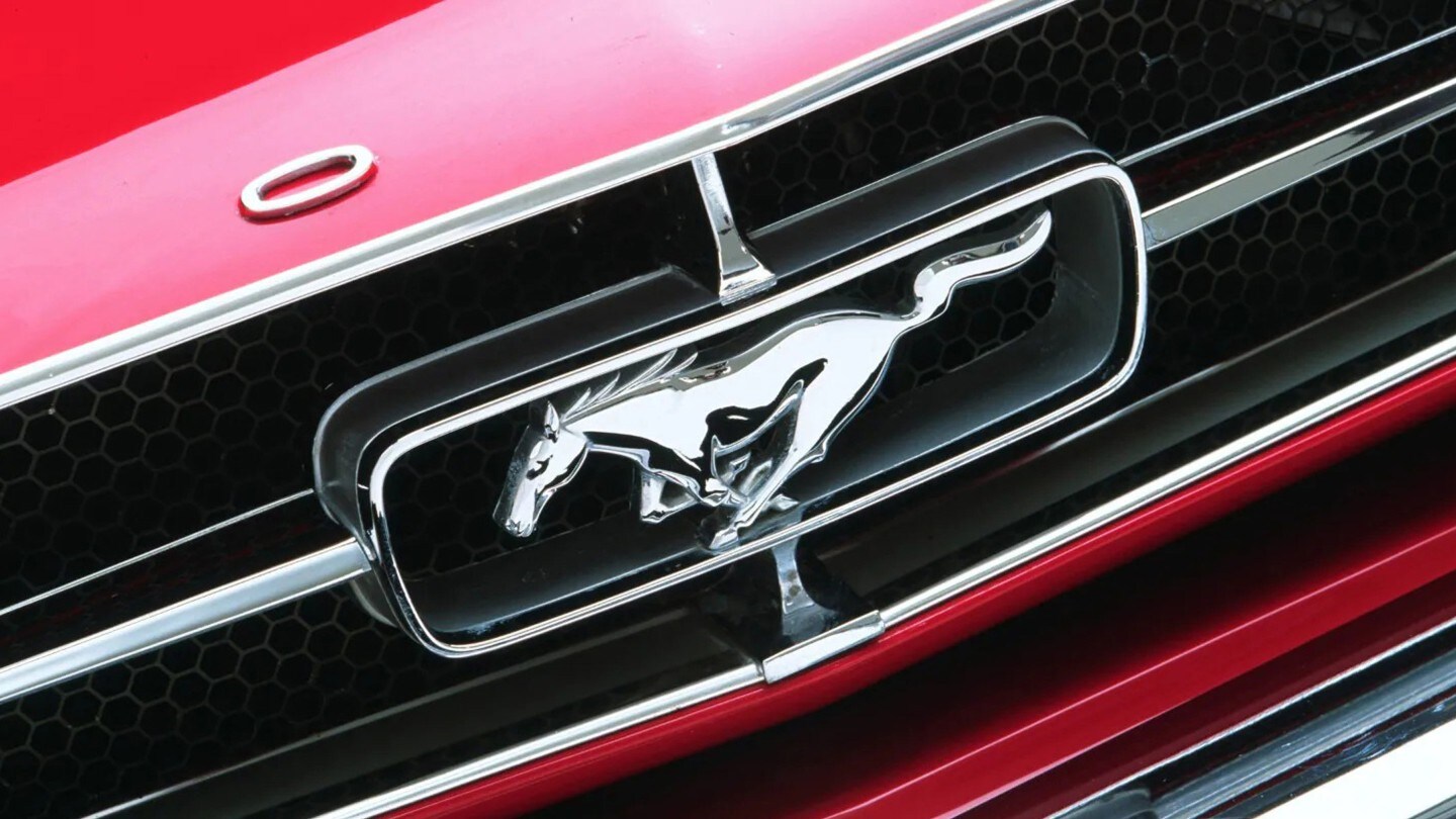 Ein Ford Mustang Logo in der Nahaufnahme auf einem roten Ford